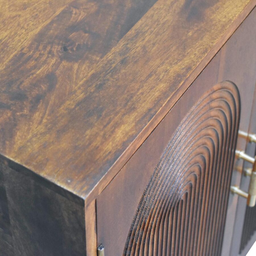 Wooden cabinet corner with brass hinges.