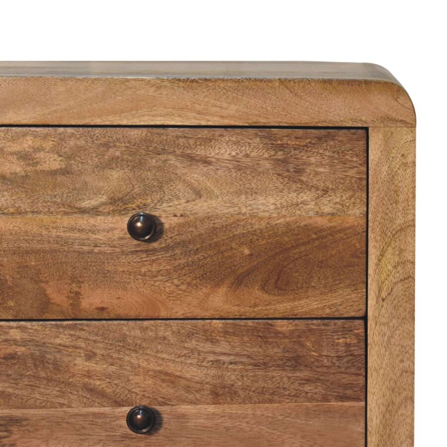 Wooden chest of drawers with dark knobs.