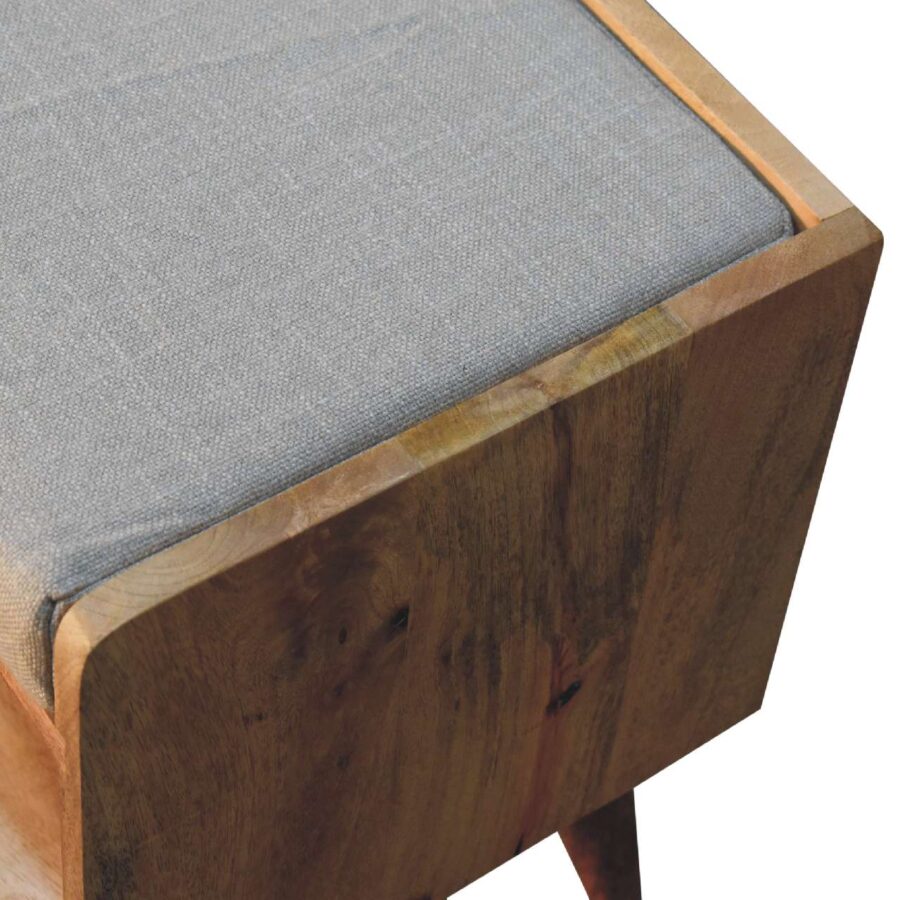 Close-up of wooden stool with grey cushion.