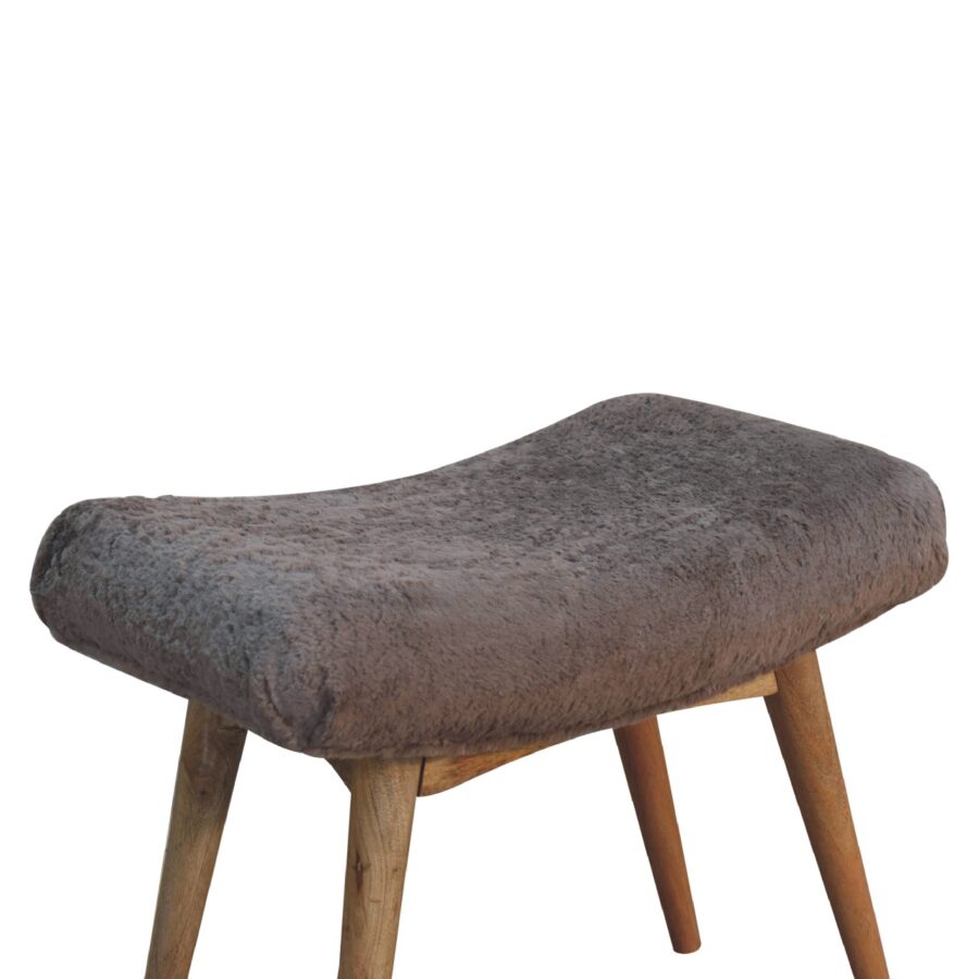 Furry brown cushioned stool on wooden legs.