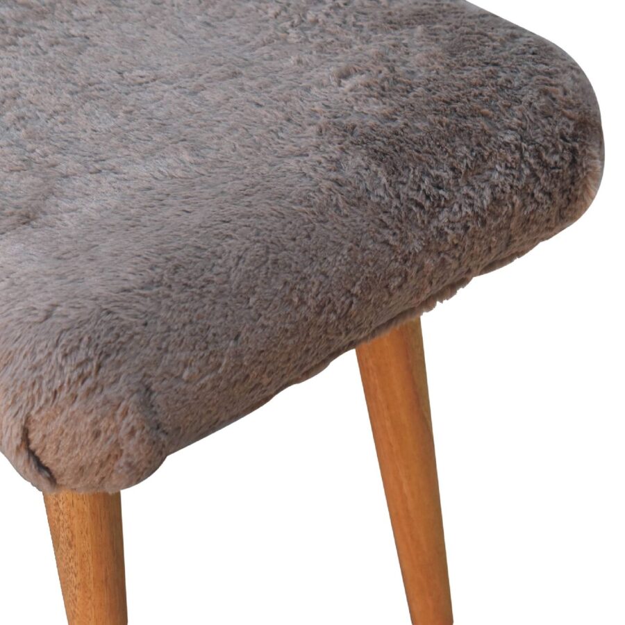 Grey upholstered chair with wooden legs.