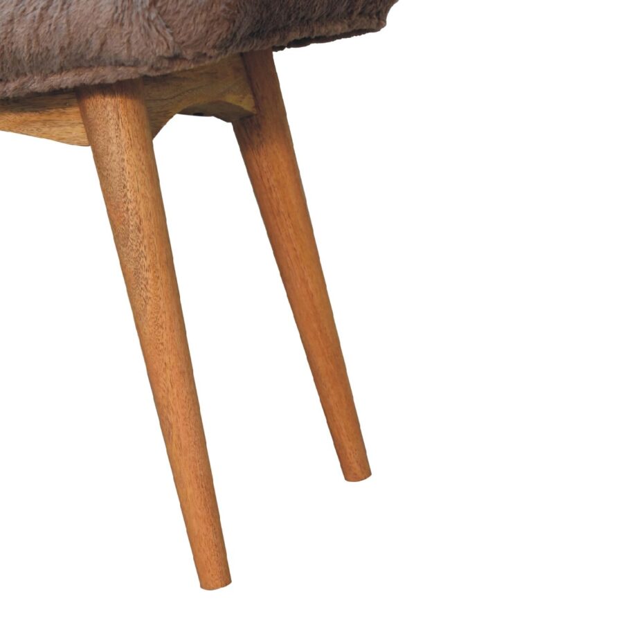 Wooden stool legs with fur seat detail.