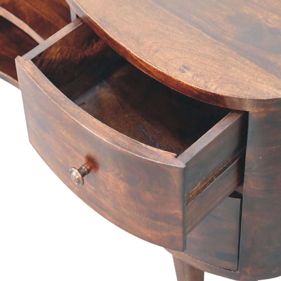 Kulatý dřevěný stůl s otevřenou zásuvkou.