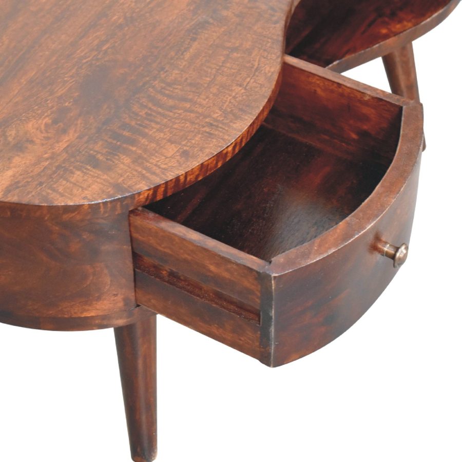 Okrogla lesena miza z odprtim predalom.