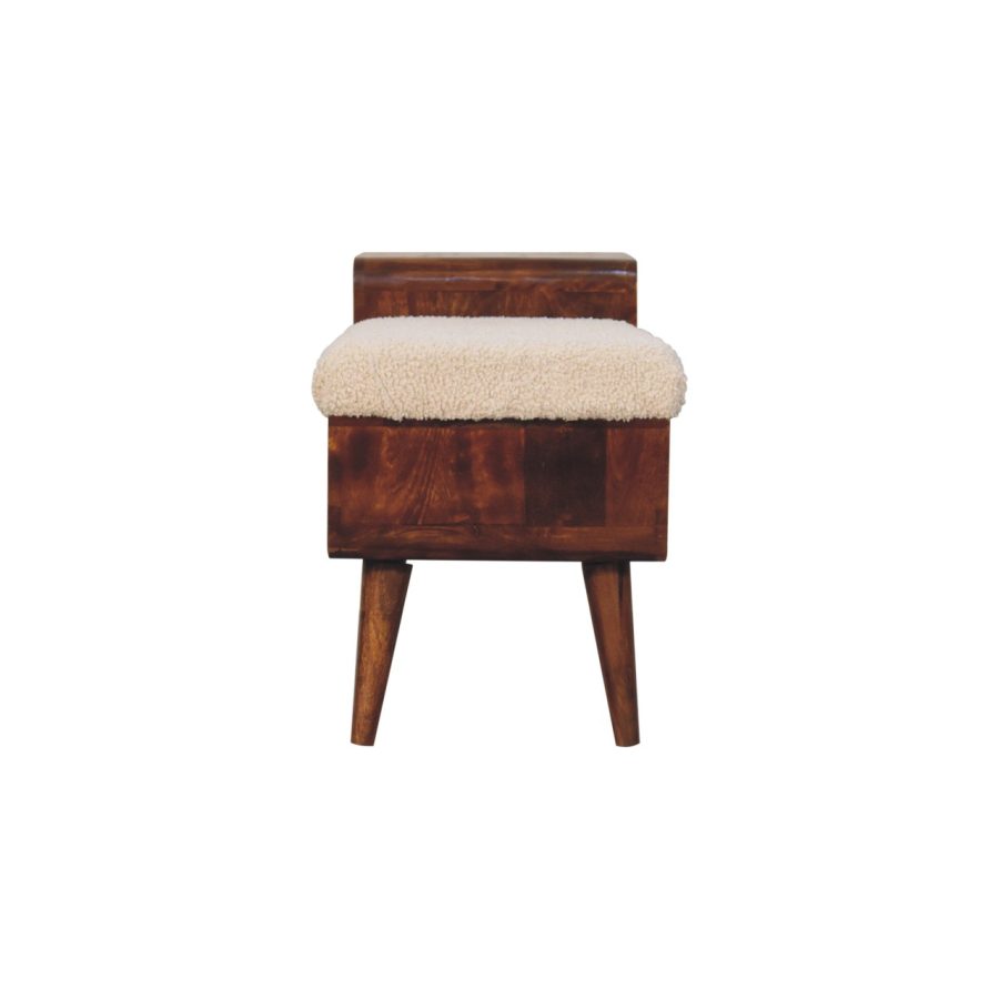 Drewniany stołek z poduszką do siedzenia ze skóry owczej.